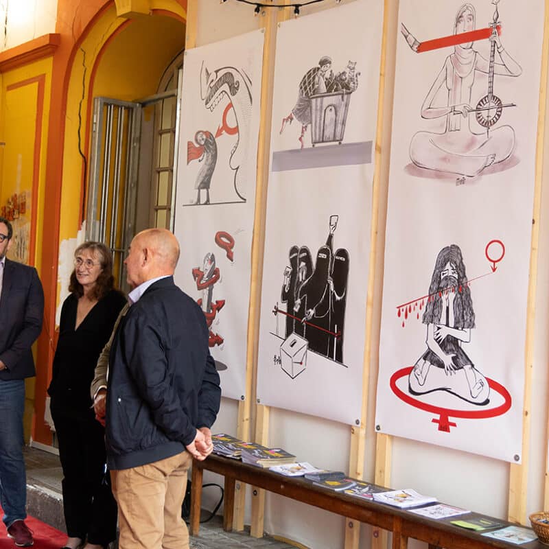 Photo du vernissage de l'exposition Rouge Tapis. 4 personnes discutent devant les dessins de Firoozeh Mozaffari que l'on aperçoit. On se trouve à l'entrée de la Maison des Francophonies.