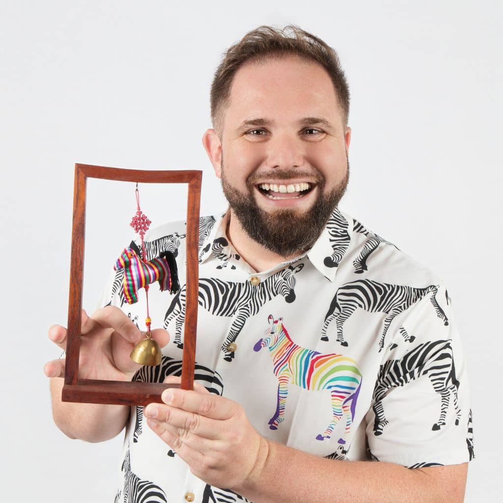 Portrait de Quentin Carrissimo-Bertola avec une chemise zèbre et une cloche zèbre dans ses mains