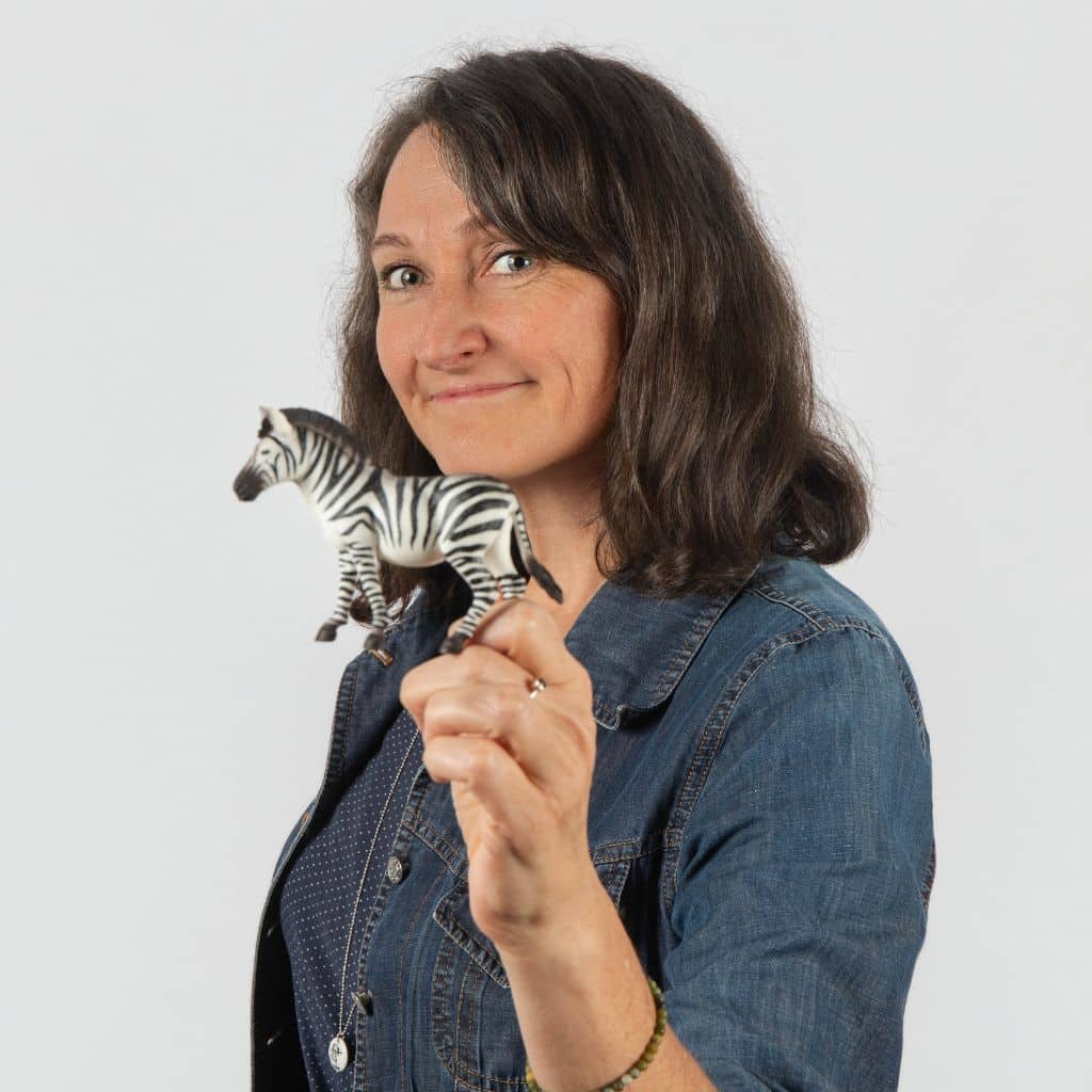 Portrait de Sandrine Ghys, avec un zèbre en plastique dans la main
