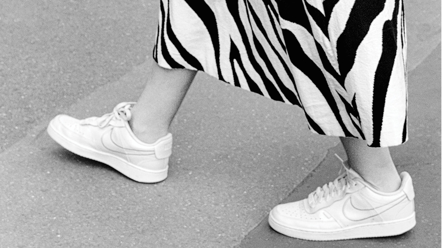 Bas d'une jupe avec un motif zébré. On distingue des jambes et de baskets