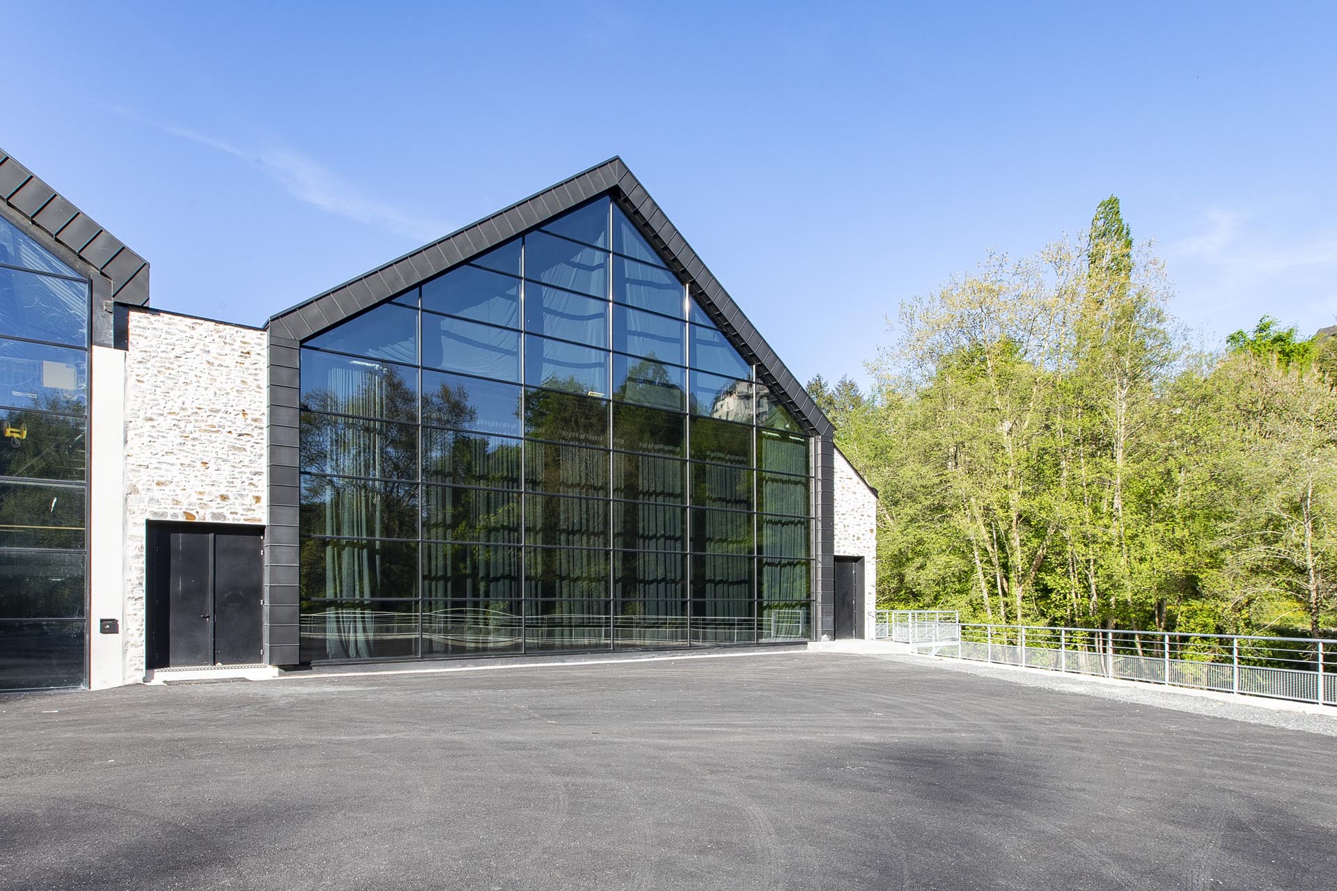 Photo de la façade vitrée de l'auditorium et des arbres sur le côté droit de l'image